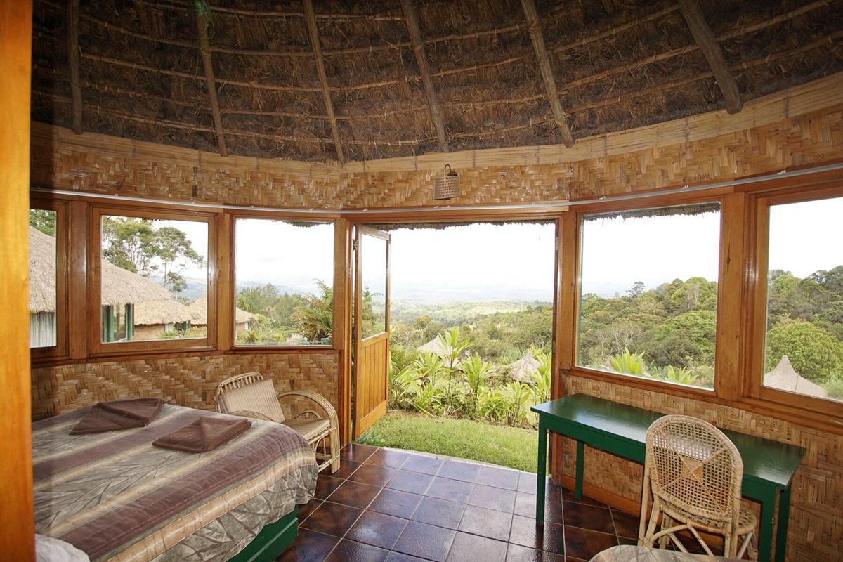 Inside a round house at Ambua Lodge, with picture windows looking out over the highland forest