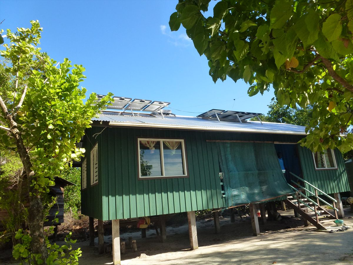 The green timber ranger station on stilts among the trees, with solar panels on its roof