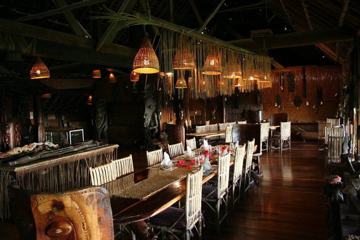 The dining room at Karawari Lodge, with woven lampshades and Sepik carvings