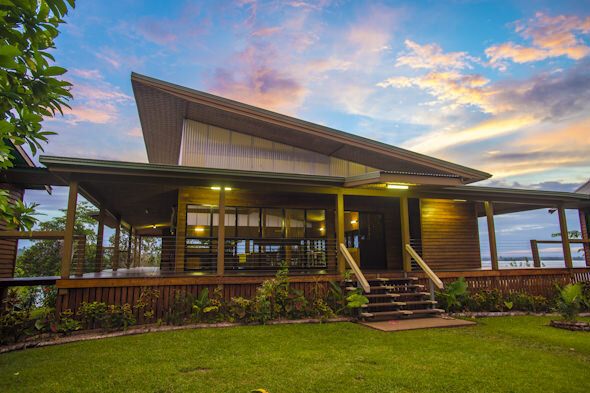 The main lodge building at Lake Murray Lodge, with its wraparound veranda, under a sunset sky