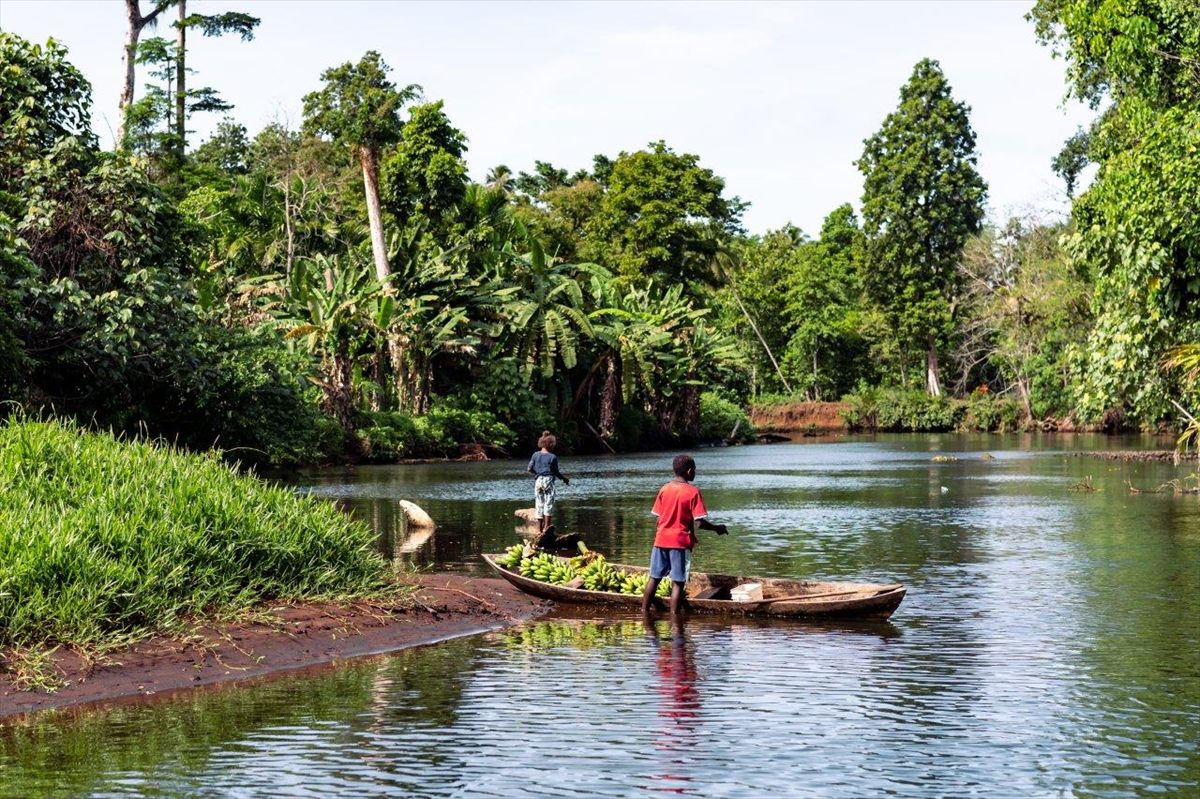 Local children with a dugout canoe loaded with bananas on the Malaga River