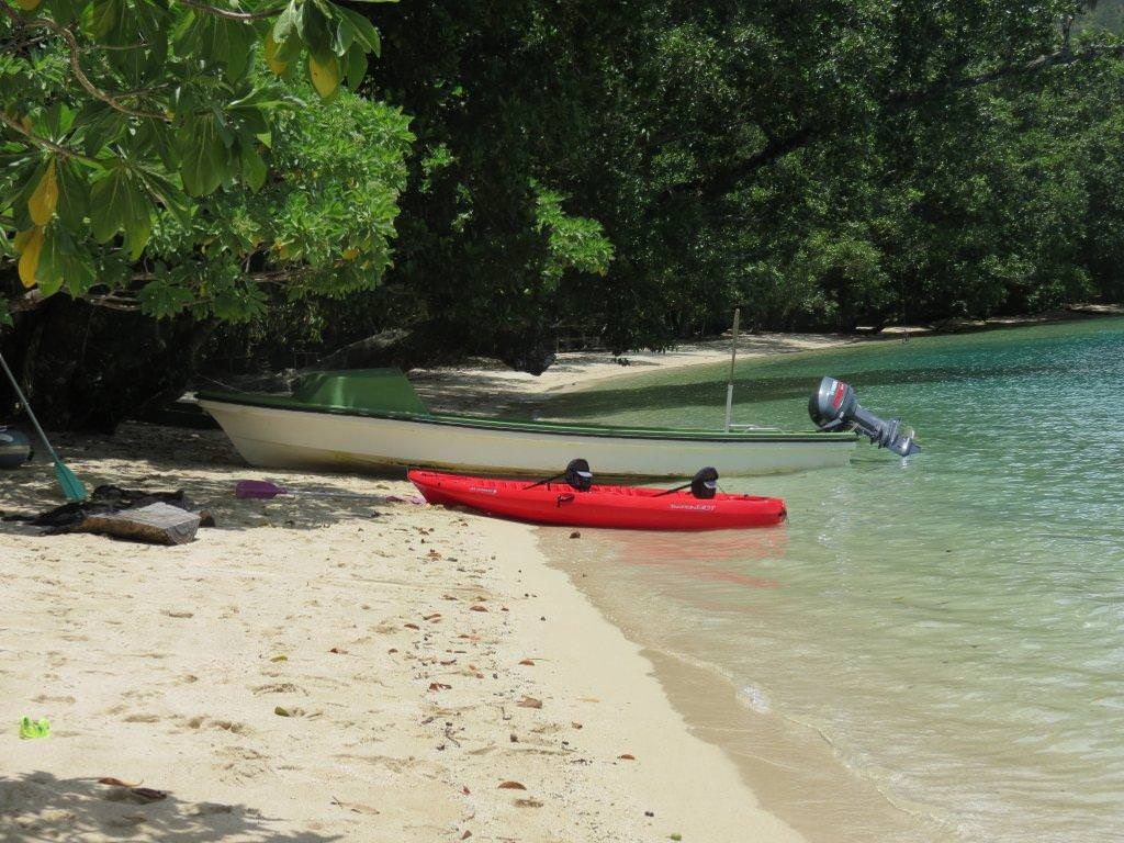 A boat and a kayak pulled up on Nugu's white sand beach