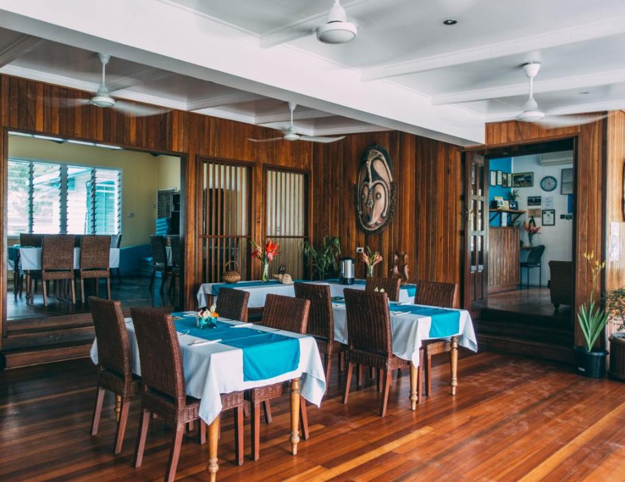 The timber-panelled restaurant at Rapopo Plantation Resort, its tables laid with white cloths and blue runners