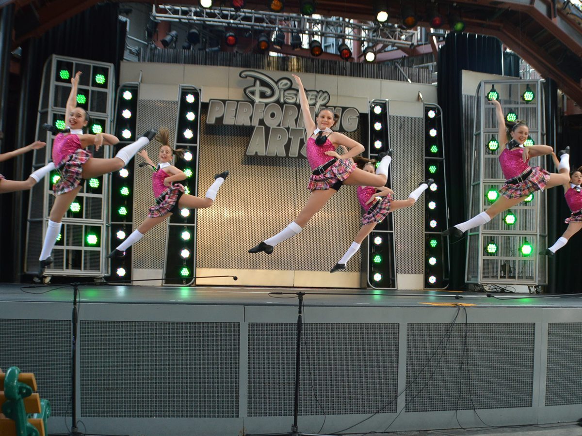 Dancers mid-leap on the Disney Performing Arts stage